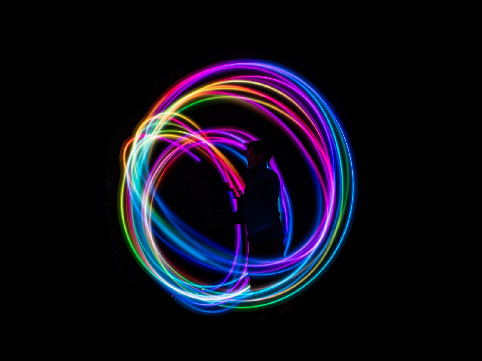 Design of a swirl of colours on a black background.